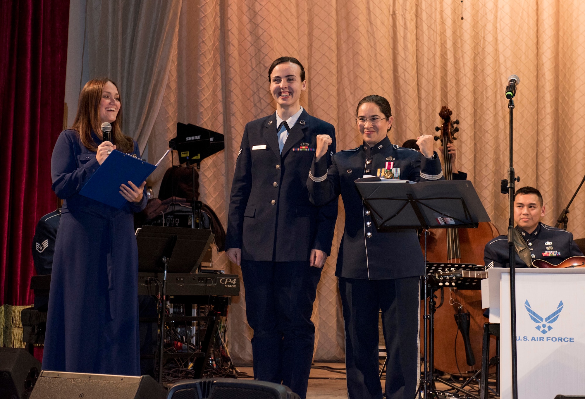Airman 1st Class Jennifer Zima, 501st Combat Support Wing Public Affairs photojournalist, is introduced on stage by Maria Lebovka, media manager and interpreter for the U.S. Air Forces in Europe Ambassadors Jazz Band’s Ukraine tour, and Lt. Col Cristina Moore Urrutia, USAFE Band commander and conductor, during a concert with the USAFE Band and the Ukrainian National Presidential Orchestra at the Philharmonic in Chernivisti, Ukraine, Oct. 12, 2019. The USAFE Band traveled to six cities in central and western Ukraine October 6-20, 2019 to conduct the “Music of Freedom” tour, which celebrated the shared spirit of freedom and enduring partnership between U.S. and Ukrainian armed forces. Zima is originlly from Ukraine and returned for the first time since her childhood as the photojournalist for the band’s Ukraine tour. (U.S. Air Force photo by 1st Lt. Sarah Johnson)