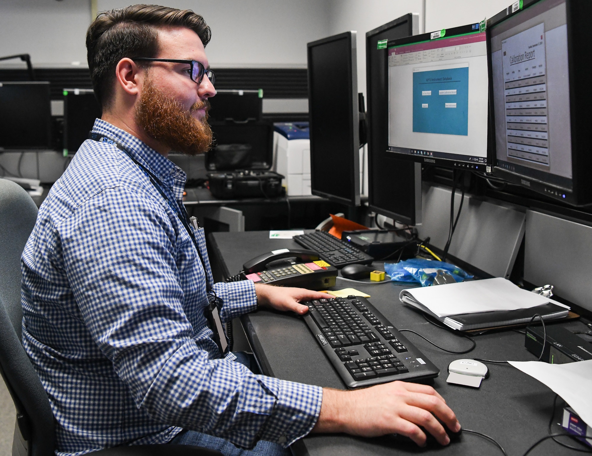 Gareth Penfold, an instrumentation, data and control engineer, views the digital database he created to track calibration requirements for test, measurement and diagnostic equipment used in the AEDC Aerodynamic and Propulsion Test Unit at Arnold Air Force Base. The calibration records were previously kept in binders, then moved to a spreadsheet and now are tracked via the database created by Penfold. (U.S. Air Force photo by Jill Pickett) (This image has been altered by obscuring badges for security purposes.)