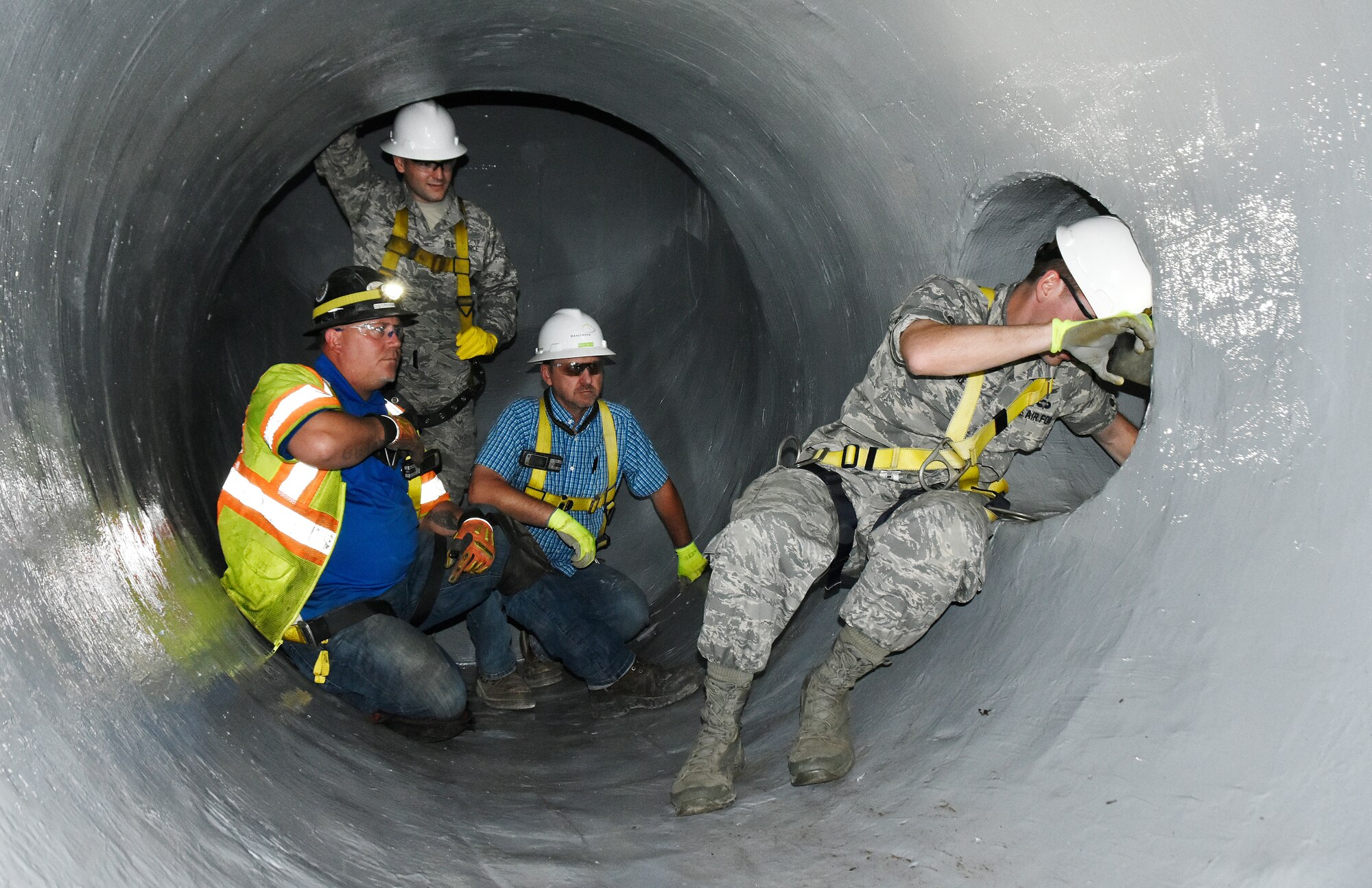 Dusty Pickens, from left, 2nd Lt. Adam Doyle and Andy Crum look on as Maj. Michael Knauf exits a 30-inch pipe in the raw water pipe system at Arnold Air Force Base. The group conducted an inspection of pipes recently lined with a fiber-reinforced polymer, Sept. 23. (U.S. Air Force photo by Bradley Hicks)