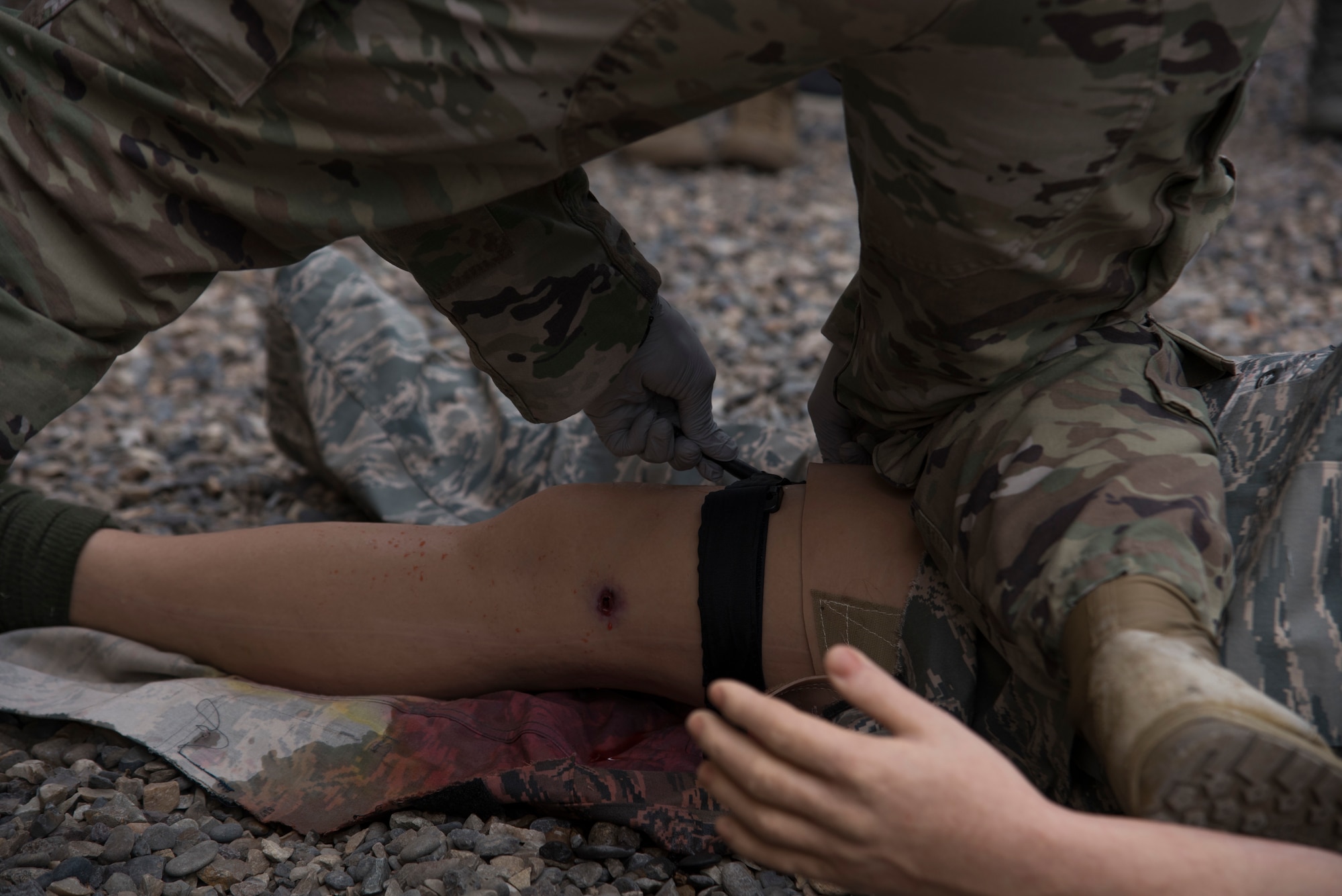 Staff Sgt. Christian Jenkins, 99th Medical Operations Squadron aerospace medical supervisor, applies a tourniquet to a simulated casualty, Sept. 16, 2019, Mountain Home AFB, Idaho. This simulation uses fake wounds, and blood to give the Airmen a sense of realism. (US Air Force Photo by Airman 1st Class Nicholas Swift)