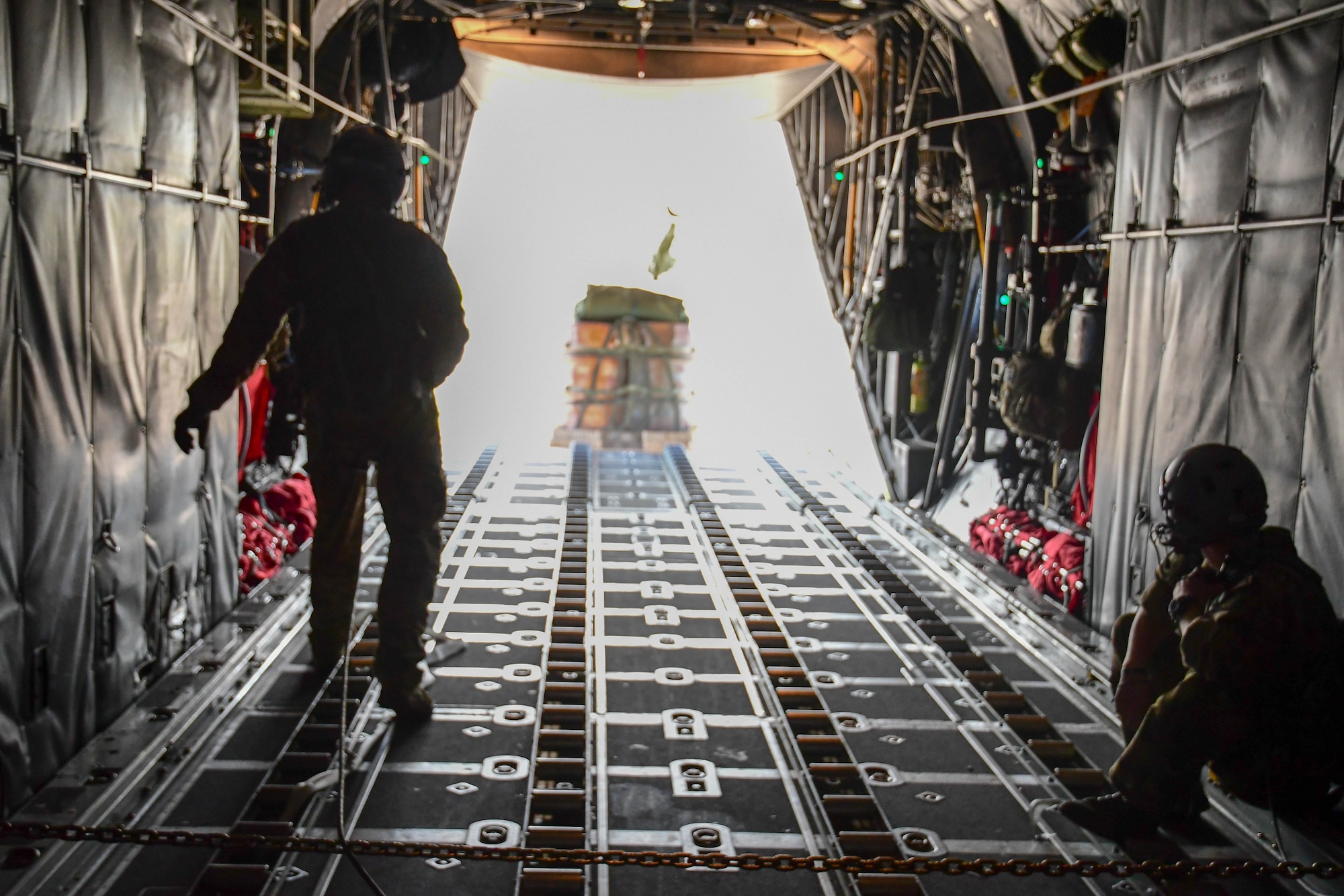 Tech. Sgt. Brian Porter (left) and Staff Sgt. Tyler Thomas, loadmasters assigned to the 700th Airlift Squadron, watch as cargo is airdropped out of the back of a C-130H3 flying near Beja Air Base, Portugal, Sep. 30, 2019 during Exercise Real Thaw 2019 . Real Thaw is a Portuguese-led multi-lateral flying training exercise intended to build trust and interoperability between NATO allies. (U.S. Air Force photo/Senior Airman Justin Clayvon)