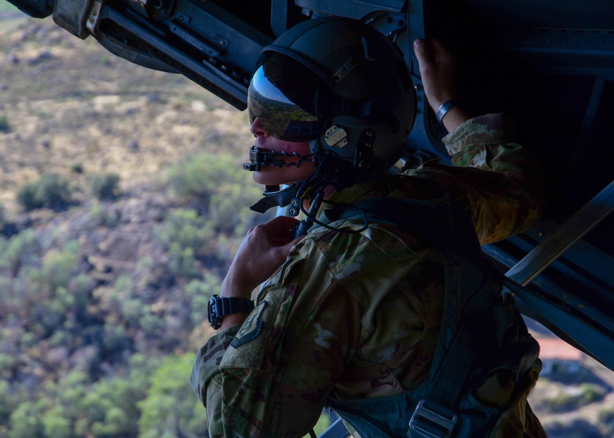 Staff Sgt. Tyler Thomas, a 700th Airlift Squadron loadmaster surveys the scenery from the back of a C-130H3 flying near Beja Air Base, Portugal, Sep. 30, 2019 during Exercise Real Thaw 2019. The purpose of the exercise is to execute tactical airlift and airdrop operations and training with the Portuguese air force where Dobbins supports the aerial functions of the exercise. (U.S. Air Force photo/Senior Airman Justin Clayvon)
