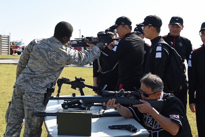 U.S. Air Force Senior Airman Josue Enalien, 8th Security Forces defender, shows members of the Republic of Korea Air Force’s 38th Fighter Group different types of weapons used in base defense operations at the 2019 Penn Fest at Kunsan Air Base, ROK, Oct. 19, 2019. Security forces, explosive ordnance disposal and firefighters provided displays and demonstrations for the audience. (U.S. Air Force photo by Staff Sgt. Joshua Edwards)