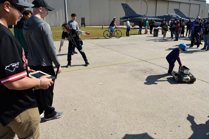 U.S. Air Force Staff Sgt. Brandon Tran, 8th Civil Engineer Squadron Explosive Ordnance Disposal NCO in charge of equipment, drives a robot to give out free candy during the 2019 Penn Fest at Kunsan Air Base, Republic of Korea, Oct. 19. 2019. EOD showcased robots to help give attendees a better understanding of how the different machines work. (U.S. Air Force photo by Staff Sgt. Joshua Edwards)