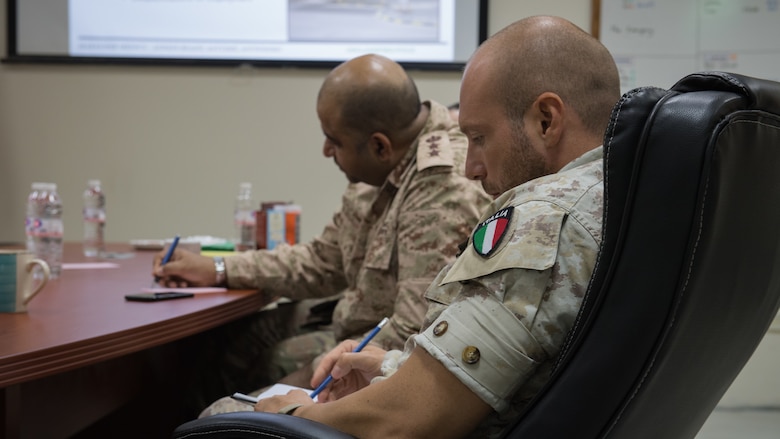 Kuwaiti army doctor, Col. Raed R. Altajalli, Kuwait North Military Medical Complex assistant director, and Italian air force Lt. Salvatore Napolitano, Task Force Air-Kuwait Flight Surgeon, takes notes during a medical brief at Ali Al Salem Air Base, Kuwait, Oct. 16, 2019. Kuwaiti military medics visited the 386th EMDG clinic to tour the facility, share ideas on improving medical care and discuss strengthening interoperability. (U.S. Air Force photo by Tech. Sgt. Daniel Martinez)