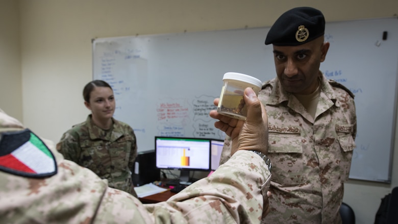 Kuwaiti army doctors and Colonels' Nawaf Jandoul Al-Dousari, right, and Raed R. Altajalli, left, view a specimen of a scorpion during a stop at the public health section of the 386th Expeditionary Medical Group clinic while visiting Ali Al Salem Air Base, Kuwait, Oct. 16, 2019. Al-Dousari and Altajalli, director and assistant director of the North Military Medical Complex respectively, visited the 386th EMDG clinic to tour the facility, share ideas on improving medical care and discuss strengthening interoperability. (U.S. Air Force photo by Tech. Sgt. Daniel Martinez)