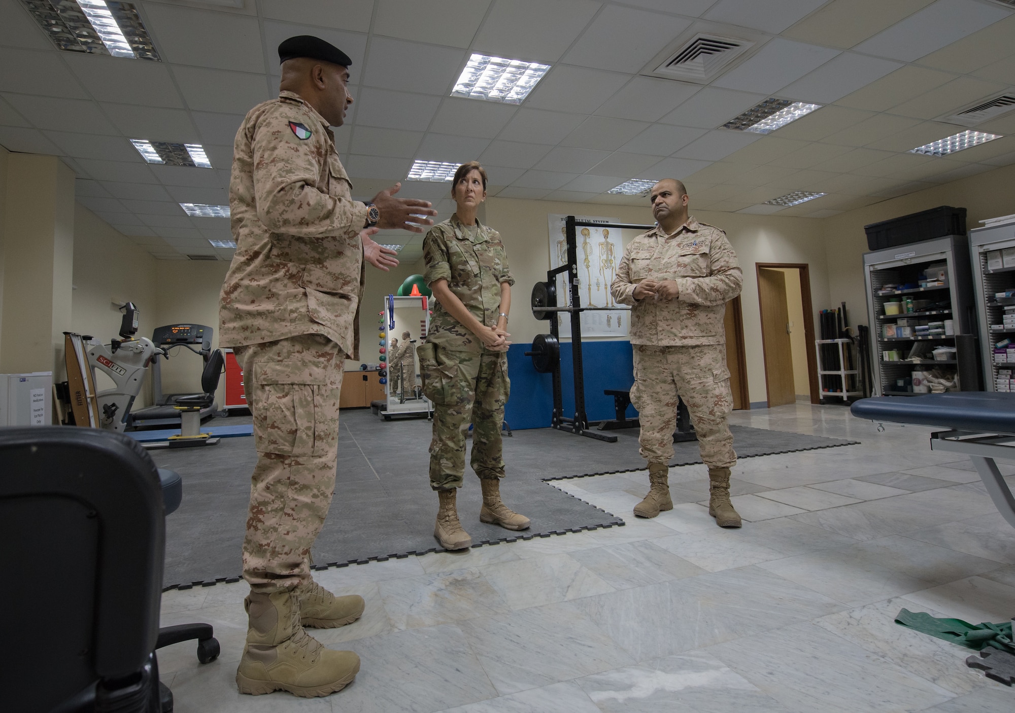 Kuwaiti army doctors and Colonels' Nawaf Jandoul Al-Dousari, left, and Raed R. Altajalli, right, have a discussion with Col. Courtney Finkbeiner, 386th Expeditionary Medical Group commander, while viewing the physical therapy rehabilitation room at the base clinic at Ali Al Salem Air Base, Kuwait, Oct. 16, 2019. Al-Dousari and Altajalli, director and assistant director of the North Military Medical Complex respectively, visited the 386th EMDG clinic to tour the facility, share ideas on improving medical care and discuss strengthening interoperability.  (U.S. Air Force photo by Tech. Sgt. Daniel Martinez)