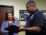 Molly Capps, principal of McDeeds Creek Elementary School in Carthage, N.C., left, signs for the computers donated to her school by U.S. Army Forces Command from Eric Garris, Defense Logistics Agency, Oct. 15.