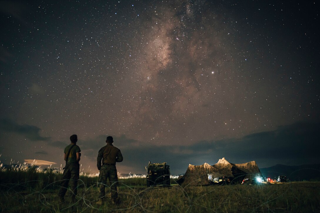 Marines look up at the stars in the night sky.