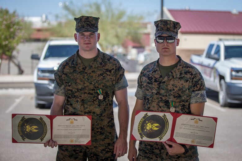 U.S. Marines with the Provost Marshalls Office, Headquarters and Headquarters Squadron, Marine Corps Air Station (MCAS) Yuma, are awarded the Navy and Marine Corps Achievement Medal on MCAS Yuma, Oct 2, 2019. The Marines were awarded the Medal for their heroic actions following a traffic accident. (U.S. Marine Corps photo by Lance Cpl John Hall)