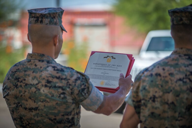 U.S. Marines with the Provost Marshalls Office, Headquarters and Headquarters Squadron, Marine Corps Air Station (MCAS) Yuma, are awarded the Navy and Marine Corps Achievement Medal on MCAS Yuma, Oct 2, 2019. The Marines were awarded the Medal for their heroic actions following a traffic accident. (U.S. Marine Corps photo by Lance Cpl John Hall)