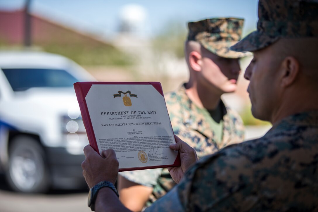 U.S. Marines with the Provost Marshalls Office, Headquarters and Headquarters Squadron, Marine Corps Air Station (MCAS) Yuma, are awarded the Navy and Marine Corps Achievement Medal on MCAS Yuma, Oct 2, 2019. The Marines were awarded the Medal for their heroic actions following a traffic accident. (U.S. Marine Corps photo by Lance Cpl John Hall)