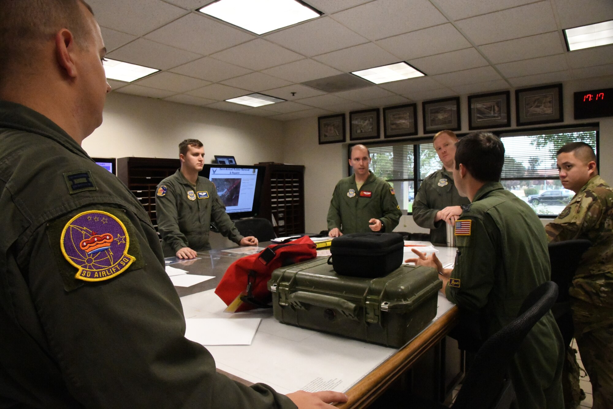 Pilots from the 3rd Airlift Squadron, Dover Air Force Base, Del., and pilots from the 21st Airlift Squadron, Travis Air Force Base, Calif., discuss preflight coordination prior to flying Oct. 16, 2019, at Travis Air Force Base, Calif. Pilots from the 3AS, and 21AS, conducted low altitude training during Weapons and Tactics Instructor Course 1-20. WTI is a seven-week training event hosted by Marine Aviation Weapons and Tactics Squadron One, which emphasizes operational integration of the six functions of Marine Corps aviation in support of a Marine Air Ground Task Force. (U.S. Air Force Photo by Tech Sgt. Esteban Esquivel)