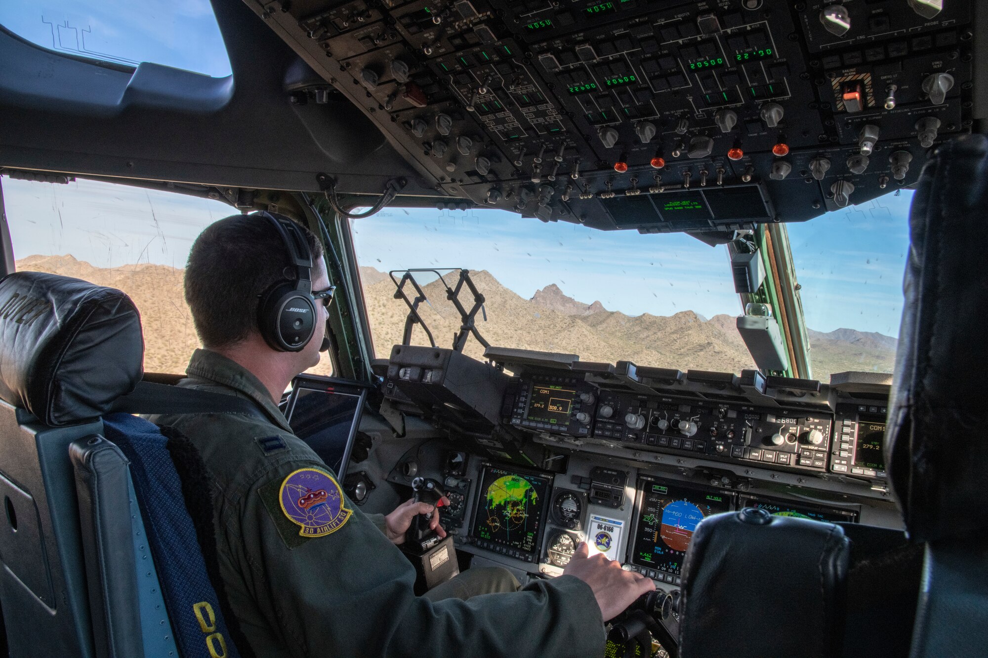 Capt. Robert Day, 3rd Airlift Squadron pilot, maneuvers a C-17 Globemaster III at low altitudes, Oct. 16, 2019, at Laguna Army Airfield in Yuma Proving Ground, Ariz. Pilots from the 3AS, Dover Air Force Base, Del., and 21st Airlift Squadron, Travis Air Force Base, Calif., conducted low-altitude training during Weapons and Tactics Instructor Course 1-20. WTI is a seven-week training event hosted by Marine Aviation Weapons and Tactics Squadron One, which emphasizes operational integration of the six functions of Marine Corps aviation in support of a Marine Air Ground Task Force. (U.S. Air Force Photo by Tech Sgt. Esteban Esquivel)