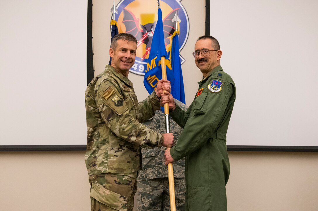 Col. Sean Carpenter, 926th Wing commander, hands the 926th Aerospace Medicine Squadron's guidon to Lt. Col. Larry Yu, 926th AMDS commander, during a change of command ceremony Oct. 20, 2019 at Nellis Air Force Base, Nevada.