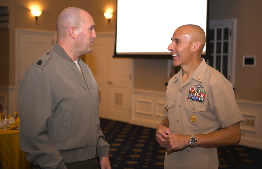Marine Corps Sgt. Maj. Robert Williamson, left, speaks with Navy Command Master Chief Frank Dominguez during the Sergeant Major of the Marine Corps Symposium in Quantico, Va., Oct. 17, 2019. The Sergeant Major of the Marine Corps Symposium is an annual event for Marine Corps Sergeants Major to gather and discuss Corps readiness, safety and future operations.