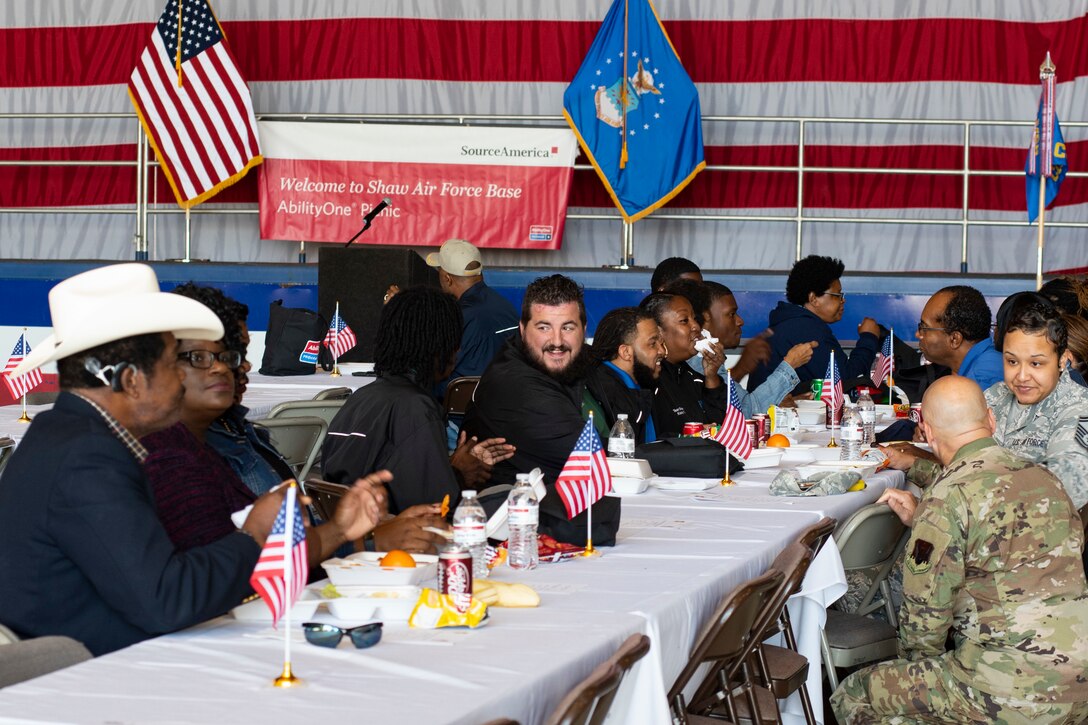 AbilityOne employees and Shaw Air Force Base (AFB) personnel eat lunch together for the 20th Annual AbilityOne picnic at Shaw Air Force Base, South Carolina, October 18, 2019.