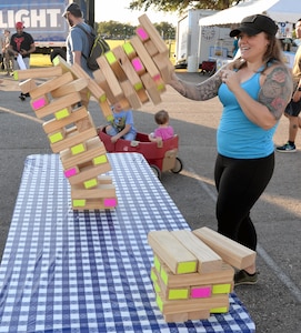 Jenga down! An attendee at the JBSA-Fort Sam Houston Oktoberfest celebration watches her Jenga tower collapse Oct. 19.