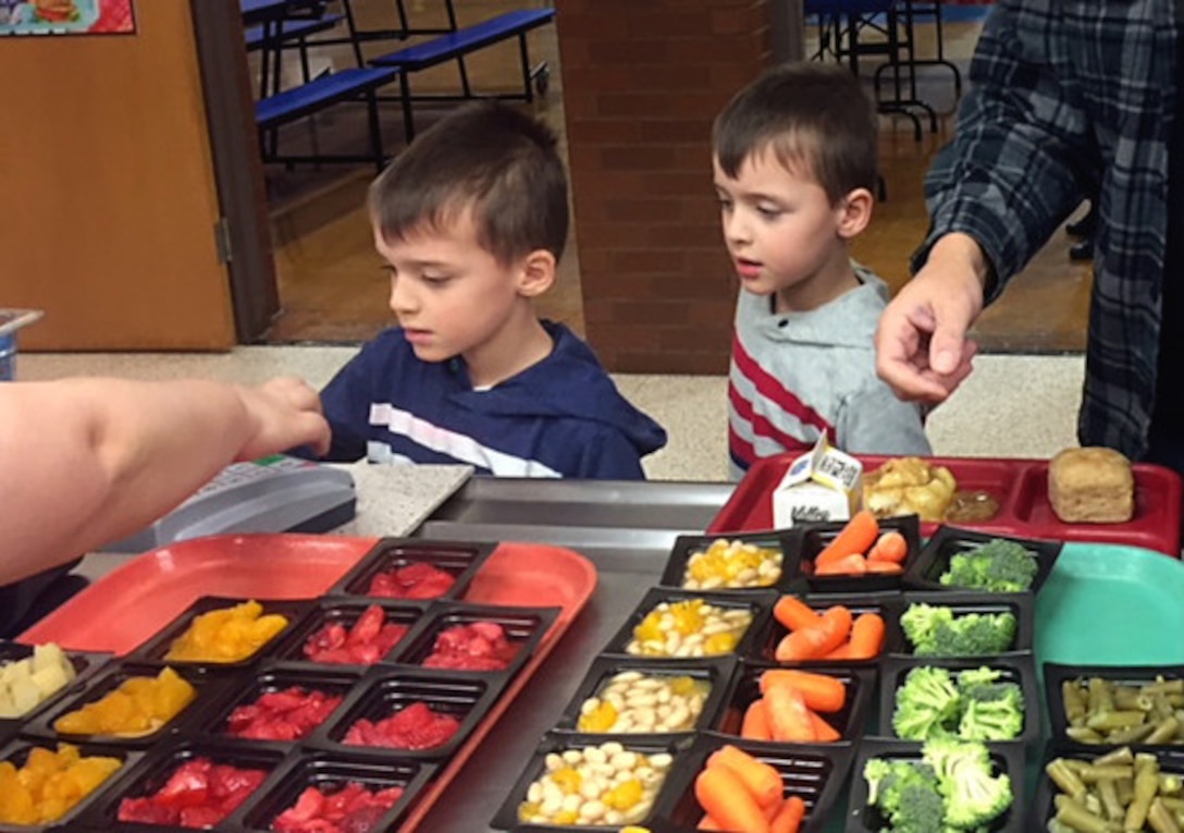 Two students proceed through the lunch line at Sayre School District in Pennsylvania. This school is one of the 45,000 schools that receives fresh fruits and vegetables through a partnership between DLA Troop Support and the USDA National School Lunch program. (Photo by Shawn Jones)