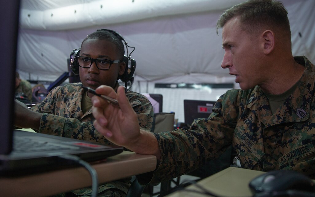 Gunnery Sgt. Zachary S. Crone, right, speaks with Marine Cpl. Trevor W. Allen during Exercise Pegasus Flight at Marine Corps Air Station Cherry Point, N.C., Sept. 30, 2019. Marine Tactical Air Command Squadron 28 supported Pegasus Flight by planning, commanding, directing and supervising all air operations as the tactical air command center for the exercise. Crone is a tactical air defense controller and Allen is a air support operations operator with MTACS-28, Marine Air Control Group 28, 2nd Marine Aircraft Wing. (U.S. Marine Corps photo by Pfc. Steven M. Walls)