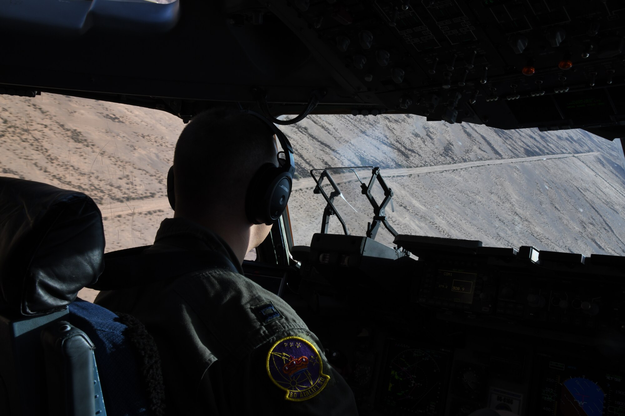 Capt. Christopher Stewart, 3rd Airlift Squadron pilot, maneuvers a C-17 Globemaster III at low altitudes, Oct. 16, 2019, at Laguna Army Airfield in Yuma Proving Ground, Ariz. Pilots from the 3AS, Dover Air Force Base, Del., and 21st Airlift Squadron, Travis Air Force Base, Calif., conducted low-altitude training during Weapons and Tactics Instructor Course 1-20. WTI is a seven-week training event hosted by Marine Aviation Weapons and Tactics Squadron One, which emphasizes operational integration of the six functions of Marine Corps aviation in support of a Marine Air Ground Task Force. (U.S. Air Force Photo by Tech Sgt. Esteban Esquivel)