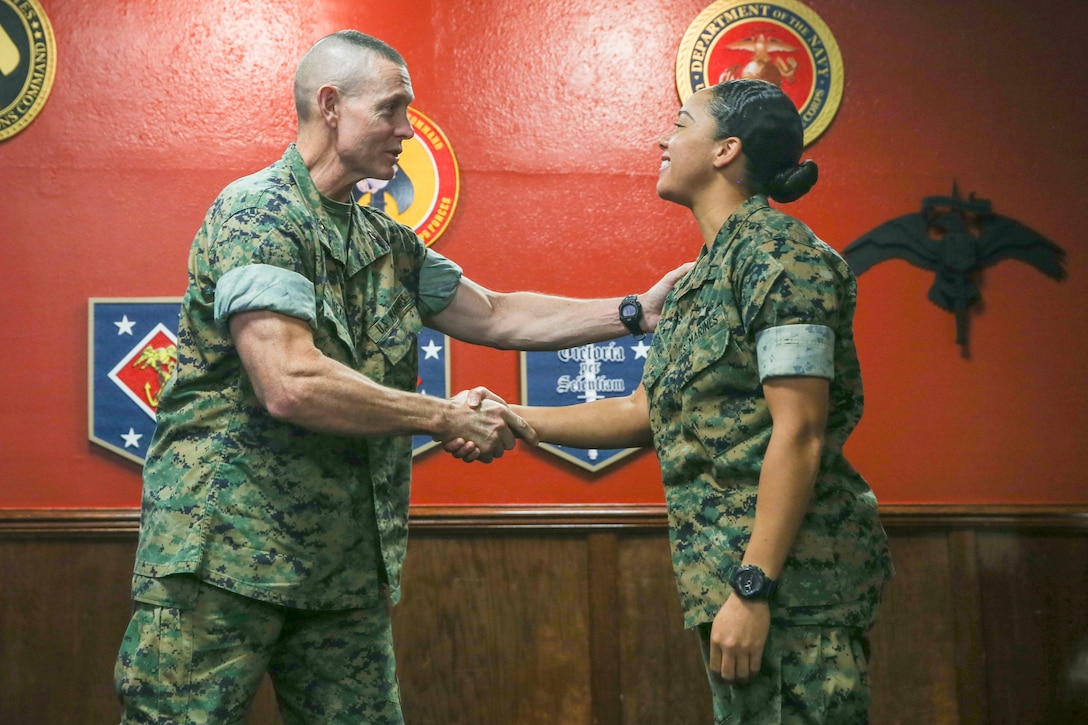 U.S. Marine Corps Maj. Gen. Stephen Neary (Left), the commanding general of 2nd Marine Expeditionary Brigade, shakes hands with Pfc. Leslie Bowie, a logistics embarkation specialist with 2nd MEB, G-4, during the Maritime Preposition Force Staff Planning Course at Camp Lejeune, N.C., Oct. 11, 2019. This training course is intended to help align II Marine Expeditionary Force and 2nd Marine Expeditionary Brigade with the Commandant’s Planning Guidance. (U.S. Marine Corps photo by Cpl. Stephen Campbell)