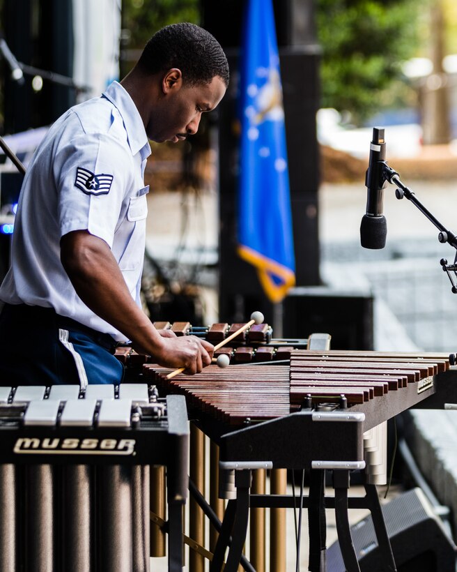 Staff Sergeant Quincy Brown performs an arrangement of Vittorio Monti's "Czardas" as a soloist with the concert band on xylophone, marimba, and vibraphone in his short sleeved blue uniform.