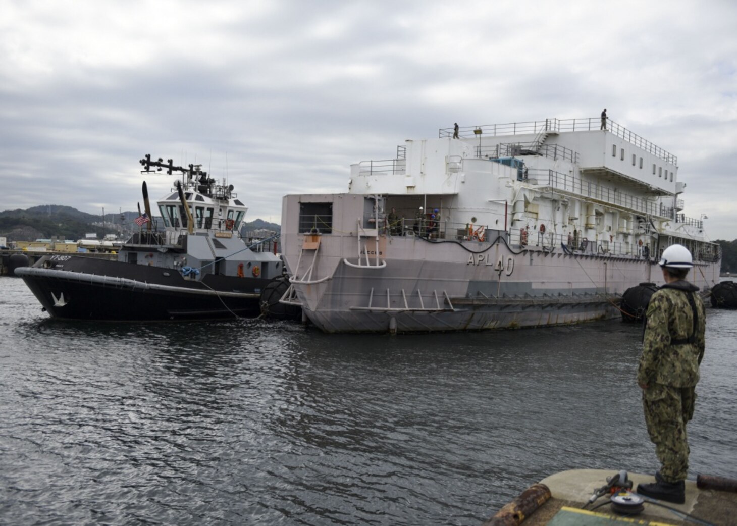YOKOSUKA, Japan (Oct. 10, 2019) Boatswains Mate 2nd Class Christie Welter, a dock master assigned to Commander, Fleet Activities Yokosuka’s (CFAY) Port Operations Department, observes the Valiant-class harbor tug Menominee (YT 807) as it assists the non-self-propelled Barracks Ship USS Nueces (APL 40) into a dry-dock in preparation for Super Typhoon Hagibis. CFAY provides, maintains, and operates base facilities and services in support of U.S. 7th Fleet's forward-deployed naval forces, 71 tenant commands, 27,000 military and civilian personnel and families.