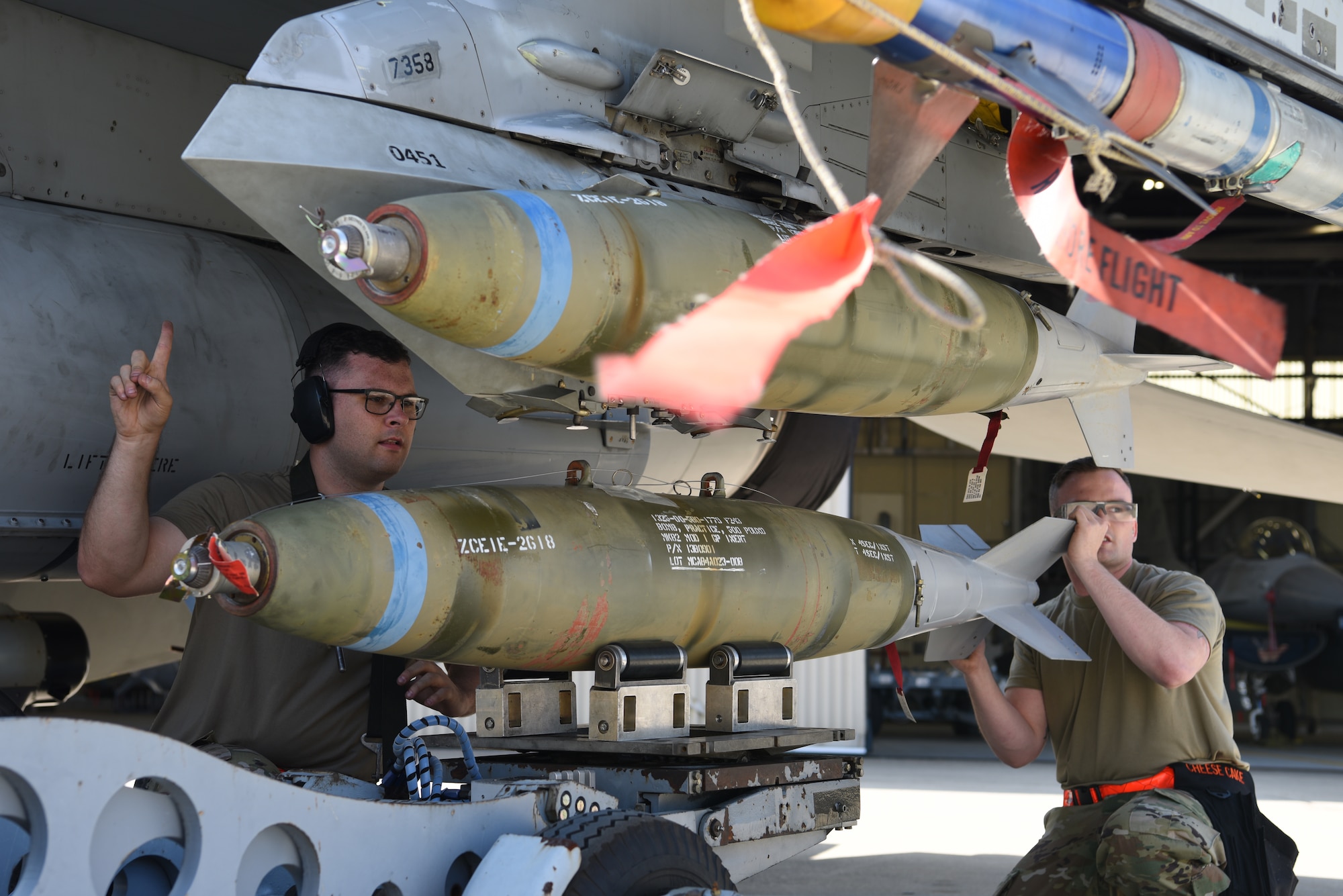 Members of the 25th Aircraft Maintenance Unit, Osan Air Base, Republic of Korea, lift a bomb during the 2019 Penn Fest competition at Kunsan Air Base, Republic of Korea, Oct. 19. 2019, The 25th AMU finished loading their aircraft the quickest and won the load crew competition overall. (U.S. Air Force photo by Staff Sgt. Joshua Edwards)