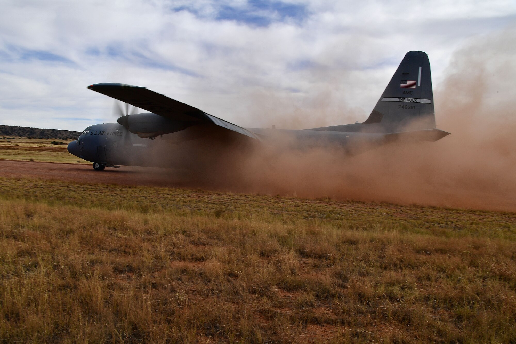 A C-130 prepares for ttakeoff on a dirt runway.