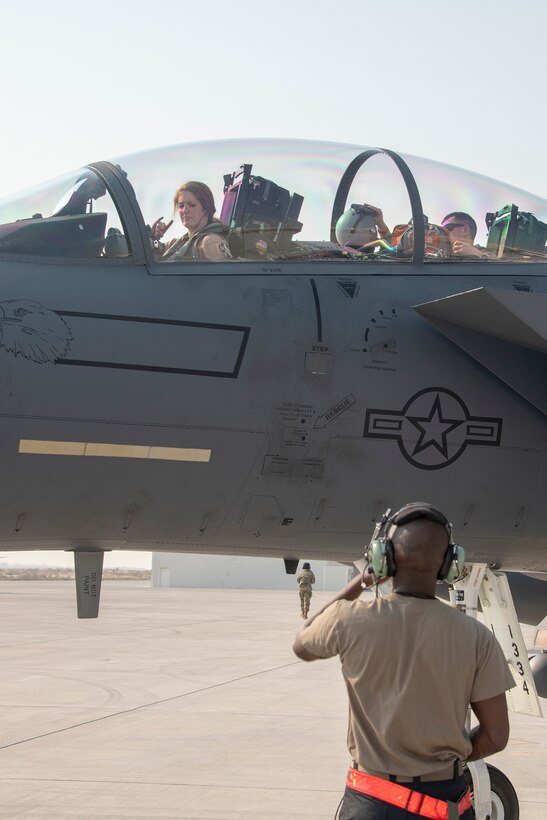 Lt. Col. Jaina Donberg, 494th Fighter Squadron commander, signals to a crew chief from the 380th Expeditionary Aircraft Maintenance Squadron, after parking Oct. 21, 2019, at Al Dhafra Air Base, United Arab Emirates.