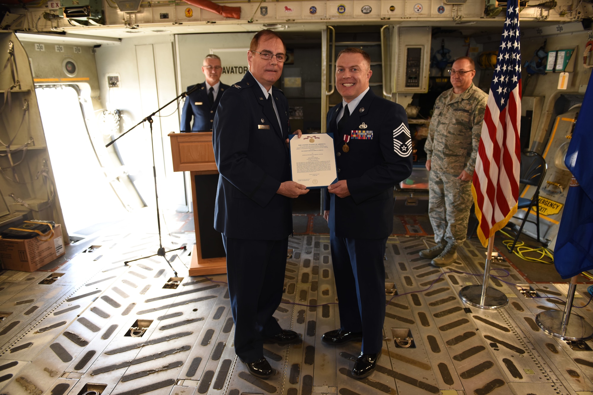 Col. Clifford Waller, commander of the 911th Maintenance Group, presents Chief Master Sgt. Timothy J. Stevens with a meritorious service medal citation during a promotion ceremony in the cargo bay of a C-17 Globemaster III at the Pittsburgh International Airport Air Reserve Station, Pennsylvania, Oct. 5, 2019.