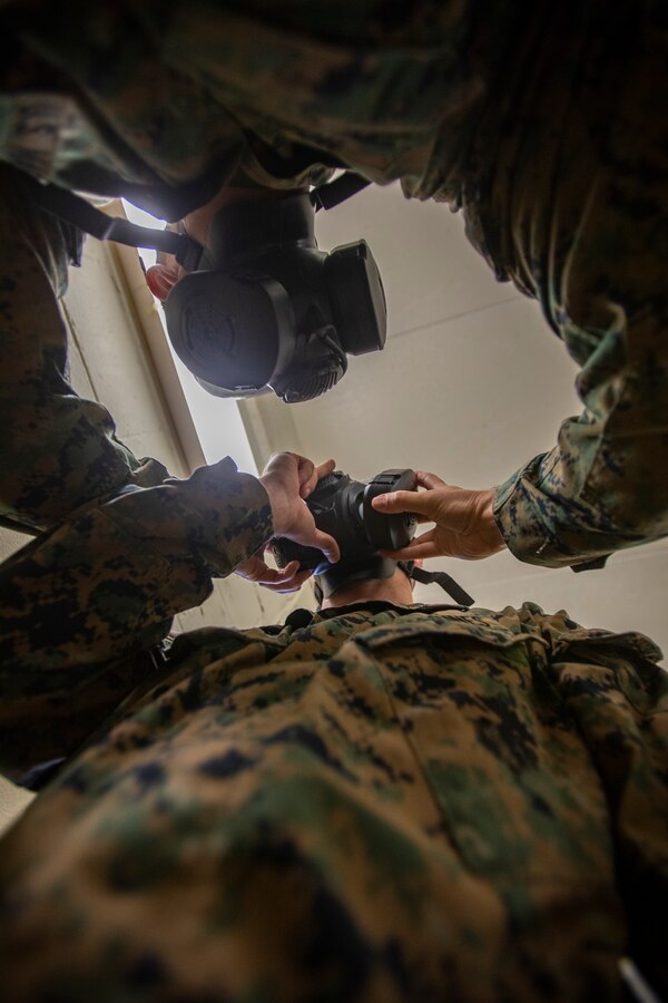 A Marine attached to Deployment Processing Command Reserve Support Unit-East, Force Headquarters Group, detaches a gas mask filter on another Marine during gas chamber training at Marine Corps Base Camp Lejeune, North Carolina, Oct. 22, 2019. The DPC/RSU-East staff provide activated Reserve units/dets various types of training such as gas chamber qualification. During the qualification, Marines are taught chemical, biological, radiological and nuclear threats, reactions to CBRN attacks, and how to take proper care and use of a gas mask. (U.S. Marine Corps photo by Sgt. Andy O. Martinez)