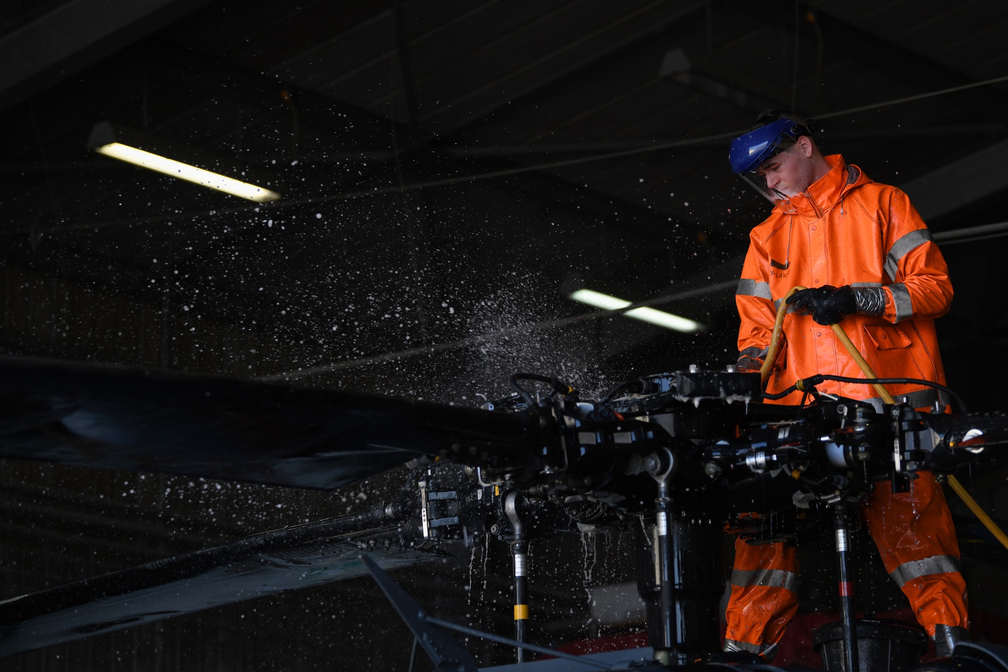 U.S Air Force Airman 1st Class Drew Marquis, a crew chief from the 31st Aircraft Maintenance Squadron, 56th Helicopter Maintenance Unit, washes the main rotor head of an HH-60G Pave Hawk helicopter at Aviano Air Base, Italy, Oct. 22, 2019. The wash was a part of an aircraft reconstitution checklist, to remove any debris from sandy conditions within desert AORs. (U.S. Air Force photo by Airman 1st Class Ericka A. Woolever).