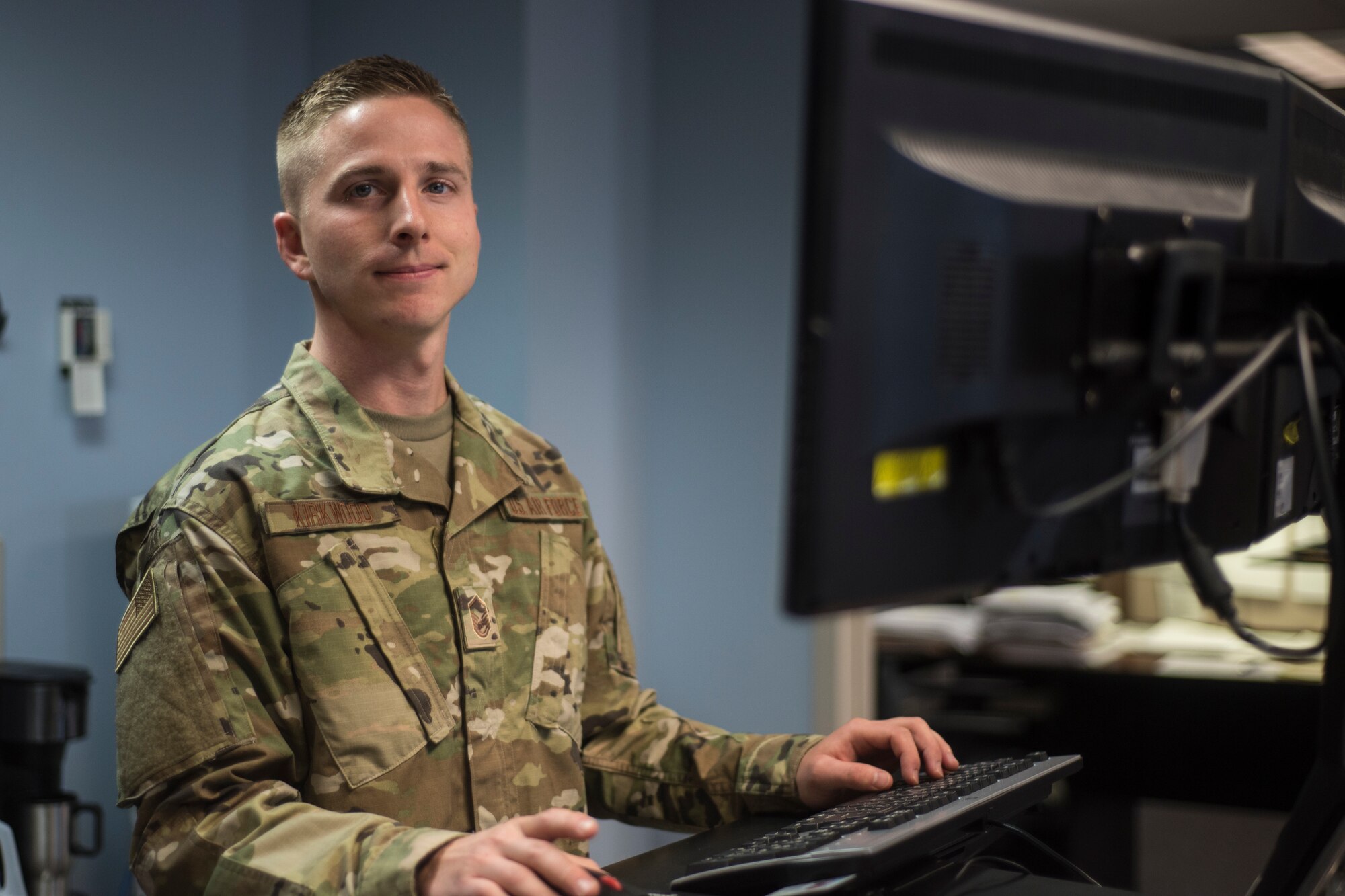 Portrait of Airman at computer looking towards to camera with hands on the keyboard
