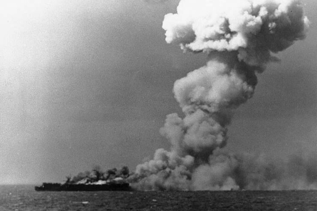 Smoke pours from an aircraft carrier.