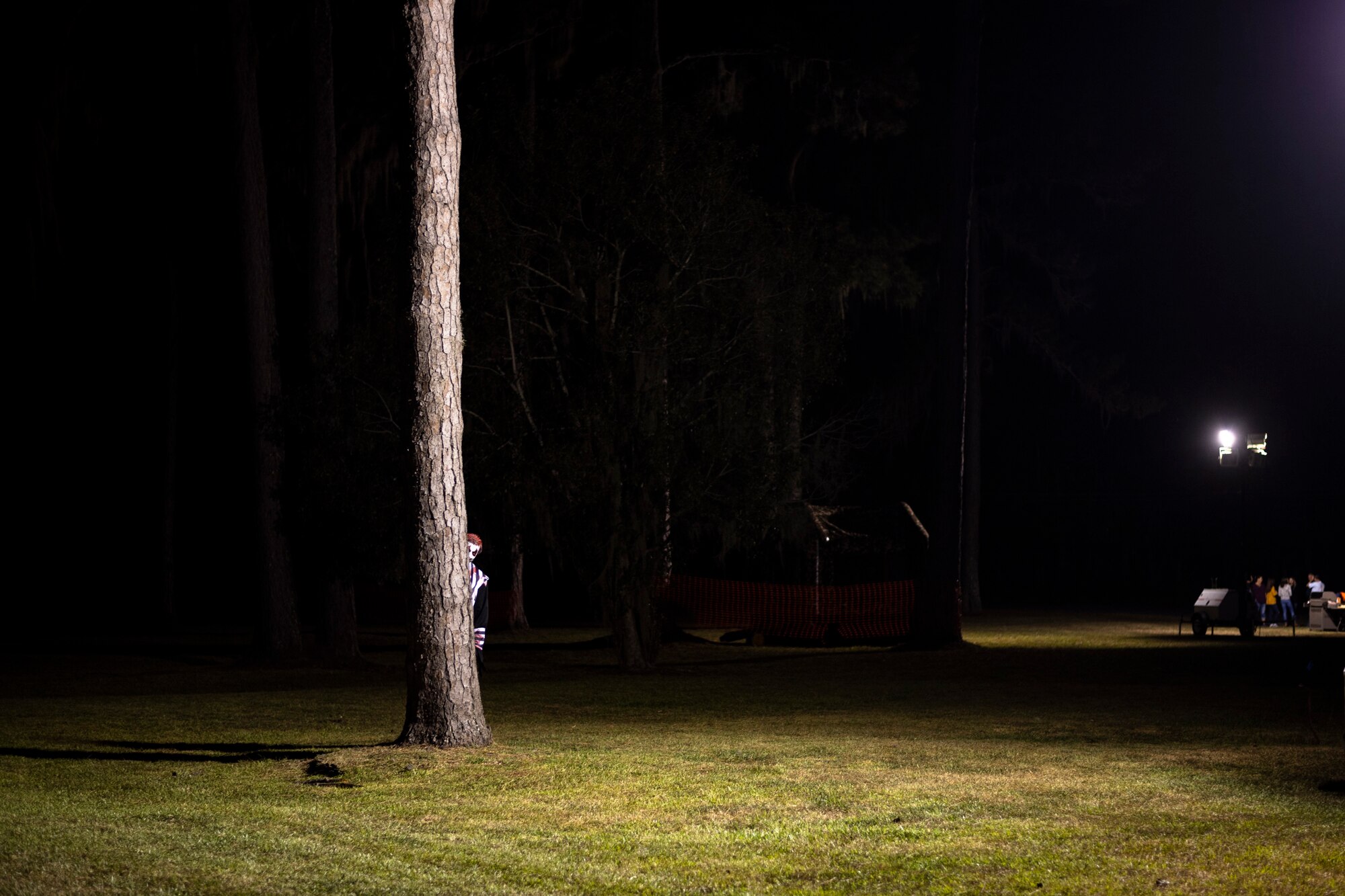 A volunteer stands behind a tree during the 40th Moooody Haunted House Oct. 18, 2019, in Valdosta, Ga. On average, it takes nearly 1,000 volunteer hours to construct and run the haunted house. It costs nearly $5K for the materials and decorations, and requires a minimum of 24 volunteers per night to operate the haunted house. (U.S. Air Force photo by Airman 1st Class Taryn Butler)
