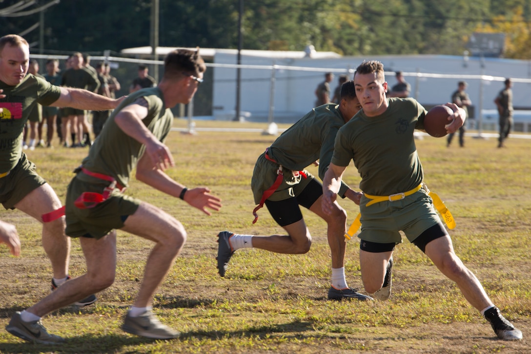 U.S. Marine Corps Cpl. Shane Oxton with Bravo Company, Fleet Anti-terrorism Security Team, Marine Corps Security Force Regiment (MCSFR), dodges opponents in a flag football tournament during a field meet October 18, 2019, at Naval Weapons Station Yorktown, Virginia. The field meet competitions included soccer, flag football, a workout competition, pugil stick bouts, and tug-of-war. The field meet was designed to increase esprit de corps within MCSFR by creating a competitive environment for Marines. (U.S. Marine Corps photo by Sgt. Danielle Prentice/released)
