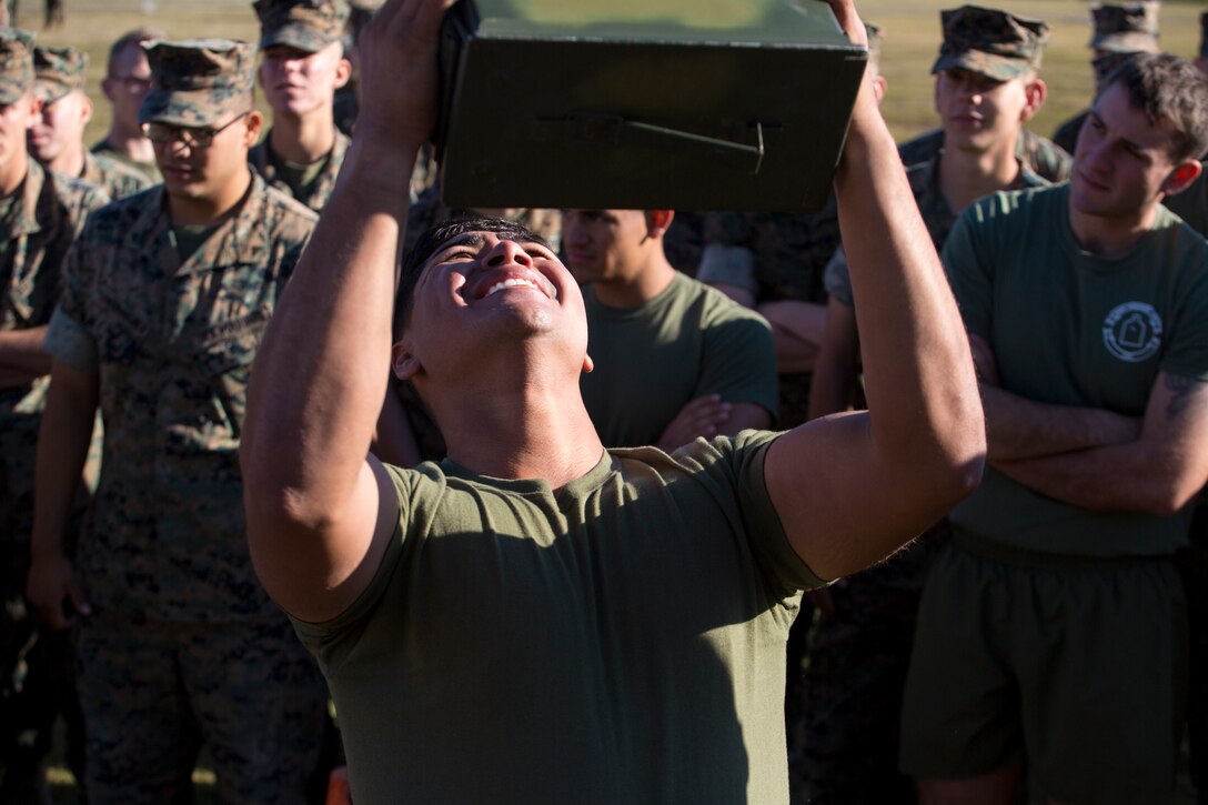 A U.S. Marine with Marine Corps Security Force Regiment (MCSFR), does ammunition can presses during a field meet October 18, 2019 at Naval Weapons Station Yorktown, Virginia. The field meet competitions included soccer, flag football, a workout competition, pugil stick bouts, and tug-of-war. The field meet was designed to increase esprit de corps within MCSFR by creating a competitive environment for Marines. (U.S. Marine Corps photo by Sgt. Danielle Prentice/released)