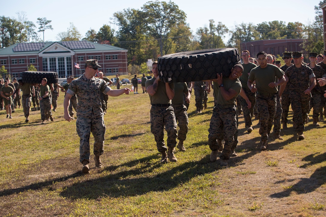 U.S. Marines with Marine Corps Security Force Regiment (MCSFR) race while carrying a tire during a field meet October 18, 2019 at Naval Weapons Station Yorktown, Virginia. The field meet competitions included soccer, flag football, a workout competition, pugil stick bouts, and tug-of-war. The field meet was designed to increase esprit de corps within MCSFR by creating a competitive environment for Marines. (U.S. Marine Corps photo by Sgt. Danielle Prentice/released)
