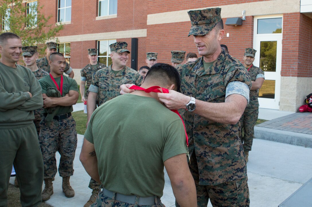 U.S. Marine Corps Sgt. Major Christopher Adams, the command sergeant major of Marine Corps Security Force Regiment (MCSFR), presents first place medals to Marine competitors after a field meet October 18, 2019 at Naval Weapons Station Yorktown, Virginia. The field meet competitions included soccer, flag football, a workout competition, pugil stick bouts, and tug-of-war. The field meet was designed to increase esprit de corps within MCSFR by creating a competitive environment for Marines. (U.S. Marine Corps photo by Sgt. Danielle Prentice/released)