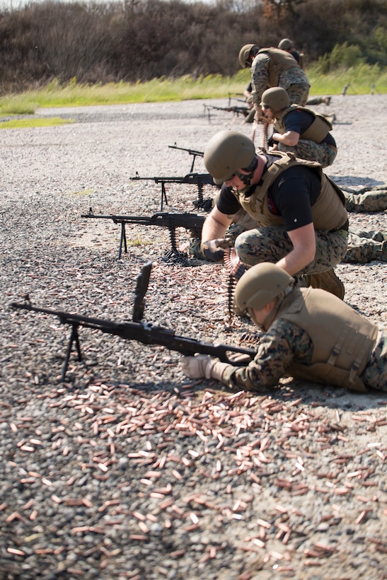 U.S. Marine Corps Sgt. Samuel B. Scott, a foreign weapons instructor with Marine Corps Security Cooperation Group, assists a shooter with a stoppage on a PKM machine gun during foreign weapons training in Moyock, North Carolina, Sept. 17, 2019.