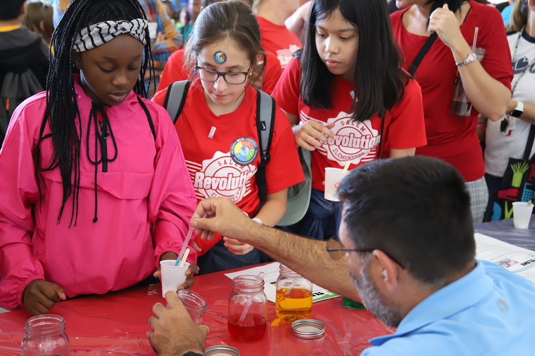 IMAGE: VIRGINIA BEACH, Va. (Sept. 20, 2019) – Scott Polack, Naval Surface Warfare Center Dahlgren Division (NSWCDD) physicist adds food coloring to a student’s slime demonstration. He was among 30 scientists and engineers from Naval Surface Warfare Center Dahlgren Division (NSWCDD) Dam Neck Activity and NSWCDD who educated students through hands-on displays at Naval Air Stations Oceana’s fourth annual Science, Technology, Engineering and Mathematics Lab. (U.S. Navy photo by George Bieber/Released)
