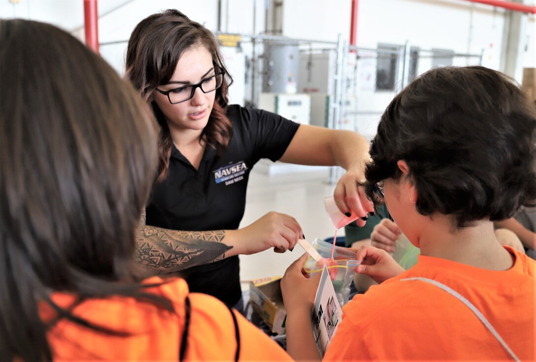IMAGE: VIRGINIA BEACH, Va. (Sept. 20, 2019) – Lauren Sencio, Naval Surface Warfare Center Dahlgren Division (NSWCDD) engineer, helps a student bag her slime. She was among 30 scientists and engineers from Naval Surface Warfare Center Dahlgren Division (NSWCDD) Dam Neck Activity and NSWCDD who educated students through hands-on displays at Naval Air Stations Oceana’s fourth annual Science, Technology, Engineering and Mathematics Lab. (U.S. Navy photo by George Bieber/Released)