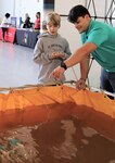 IMAGE: VIRGINIA BEACH, Va. (Sept. 20, 2019) – Luis Valcourt-Colon, Naval Surface Warfare Center Dahlgren Division (NSWCDD) engineer, helps a student operate SeaPerch, an underwater remote-controlled vehicle. He was among 30 scientists and engineers from Naval Surface Warfare Center Dahlgren Division (NSWCDD) Dam Neck Activity and NSWCDD who educated students through hands-on displays at Naval Air Stations Oceana’s fourth annual Science, Technology, Engineering and Mathematics Lab. (U.S. Navy photo by George Bieber/Released)