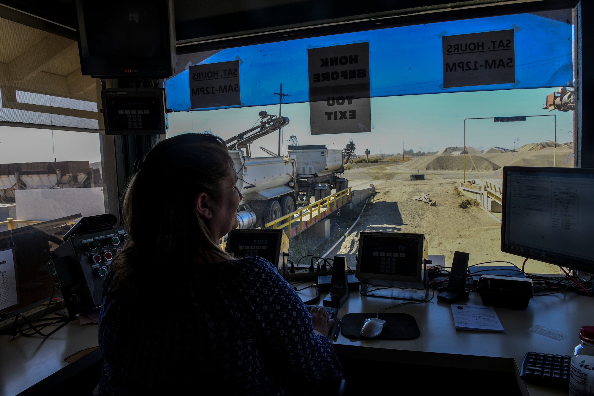 Lana Sharp, Western Aggregates weight master, communicates with trucks in Marysville, California, Oct. 10, 2019. The weight master logs their information into the system as they leave the construction yard. (U.S. Air Force Photo by Senior Airman Colville McFee)