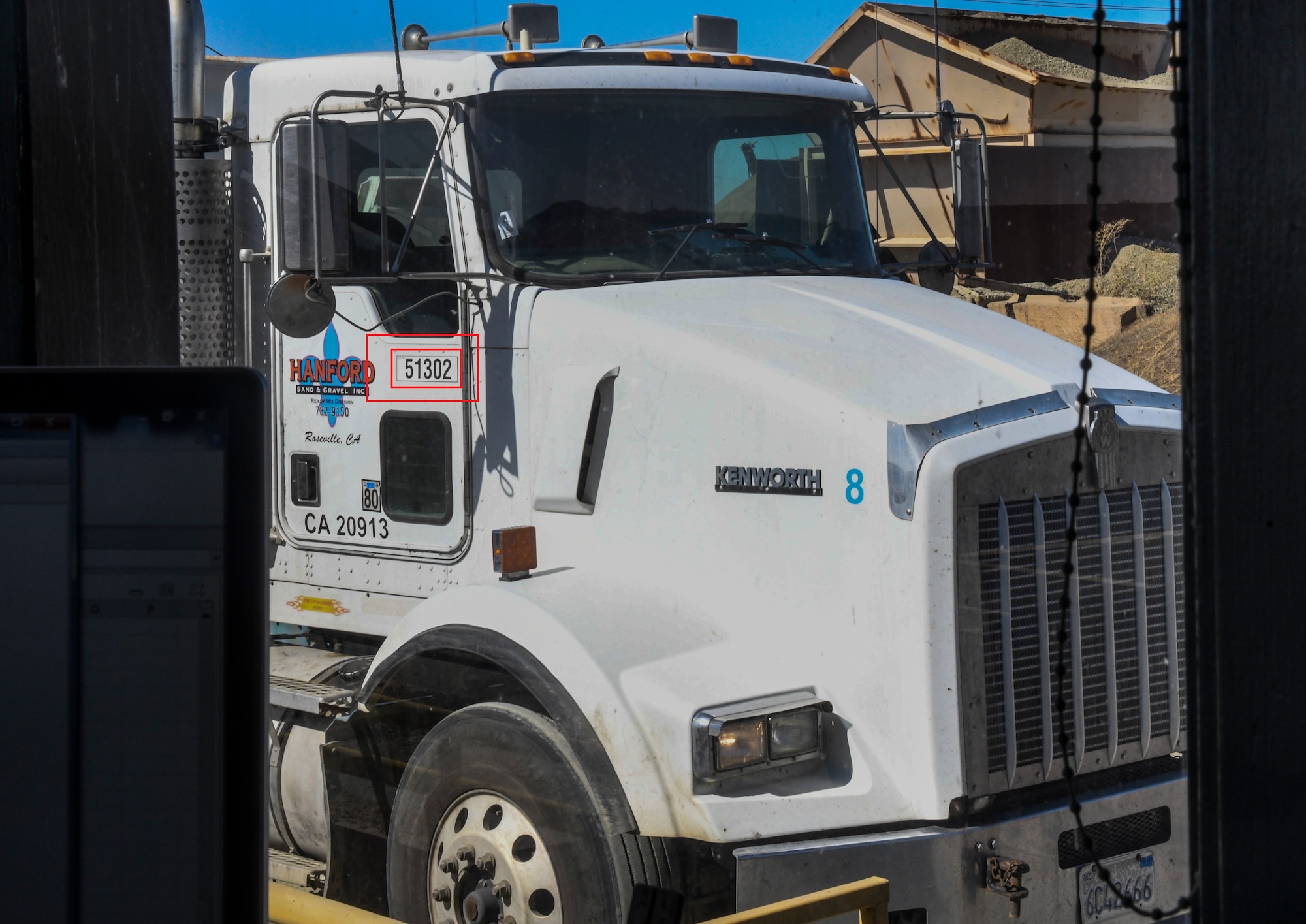 A contracted truck driver communicates with the weight master his information in Marysville, California, Oct. 10, 2019. Some indicators that can be used to identify a truck would be the five digit number (circled in red) that allows you to contact the company about any incident (U.S. Air Force Photo by Senior Airman Colville McFee)