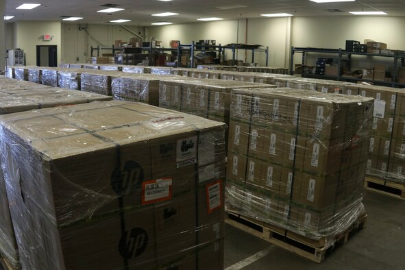 Photo shows multiple pallets with boxed laptops in a storage unit.