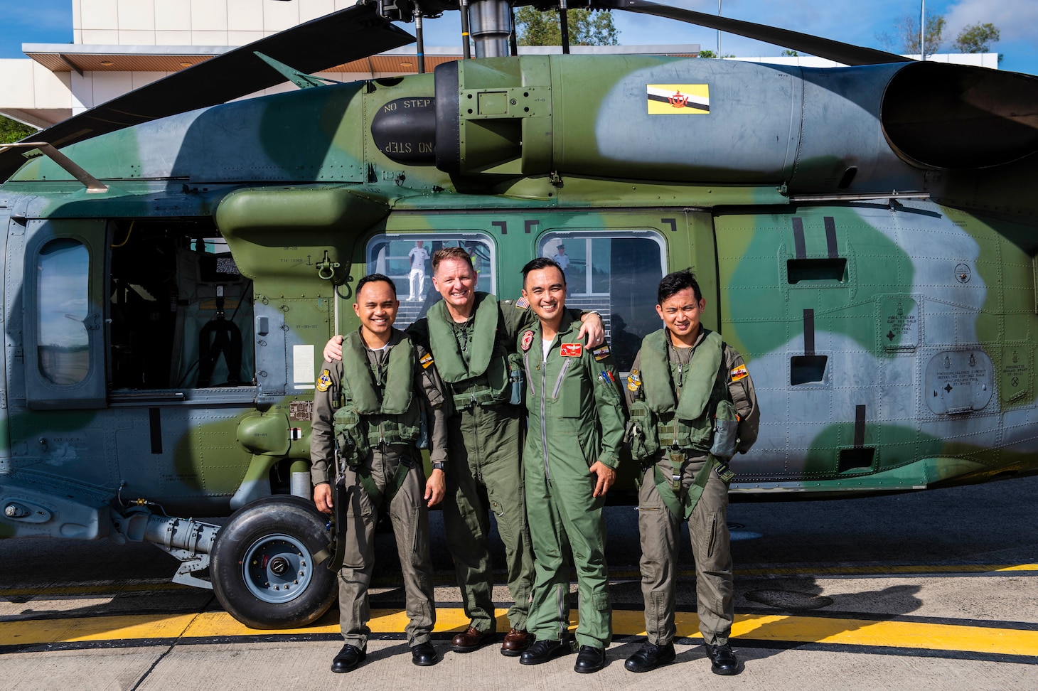 RIMBA AIR BASE, Brunei (Oct. 22, 2019) Royal Brunei Air Force (RPAirF) Lt. Col. Muhammad Walee Bin Haji Roslie , U.S. Navy Rear Adm. Joey Tynch, commander, Logistics Group Western Pacific, Cpl. Awangku Khairul Azmi Bin Pengiran Haji Ali Harun, and Sgt. Khairul Hazmi Bin Haji Abdul Razak pose in front of an S-70i Black Hawk helicopter following a bilateral flight in support of Cooperation Afloat Readiness and Training (CARAT) Brunei. This year marks the 25th iteration of CARAT, a multinational exercise designed to enhance U.S. and partner navies' abilities to operate together in response to traditional and non-traditional maritime security challenges in the Indo-Pacific region.
