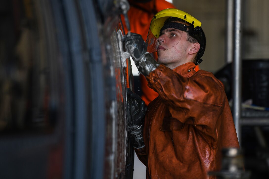 U.S Air Force Airman 1st Class Ryan Seidowsky, an instrument flight control systems specialist from the 31st Aircraft Maintenance Squadron, 56th Helicopter Maintenance Unit, scrubs an HH-60G Pave Hawk helicopter with a strong cleaning agent at Aviano Air Base, Italy, Oct. 22, 2019. The wash can take four to six hours to complete. (U.S. Air Force photo by Airman 1st Class Ericka A. Woolever).